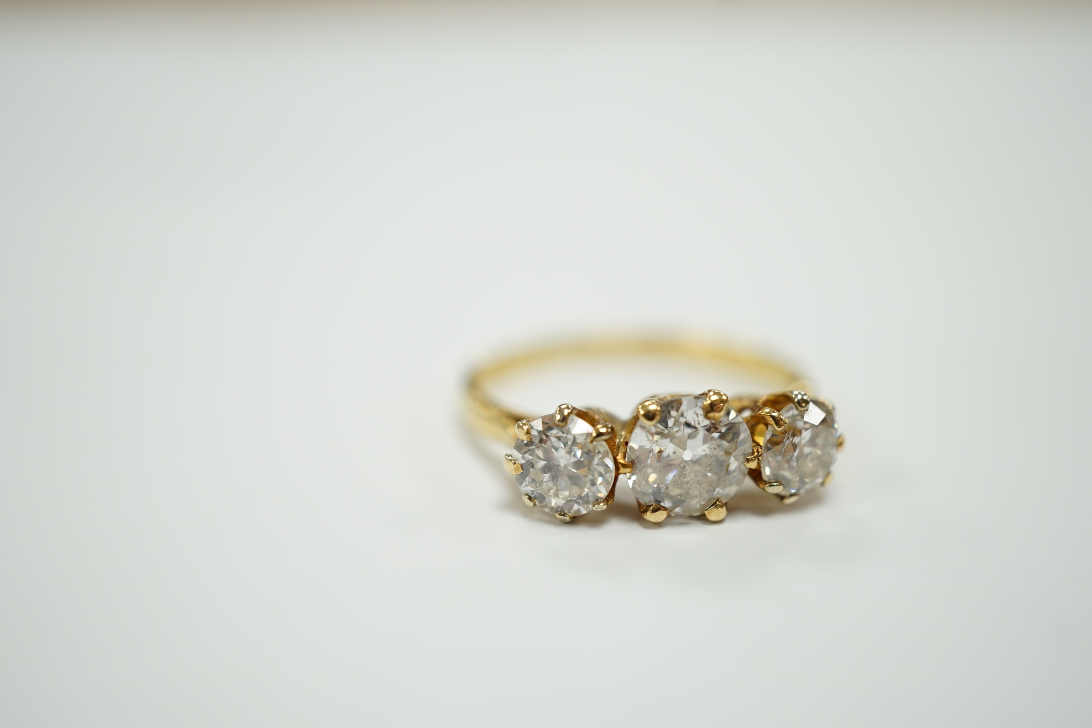 A George V 18ct gold and three stone diamond set ring, the central stone weighing approx. 0.60ct, size L, gross weight 2.5 grams.